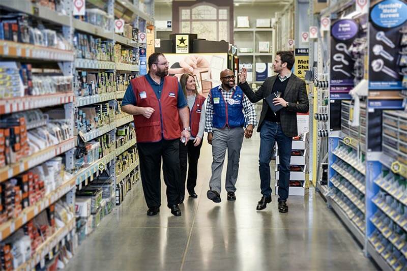 Ryan and Lowe's staff walking down a store aisle