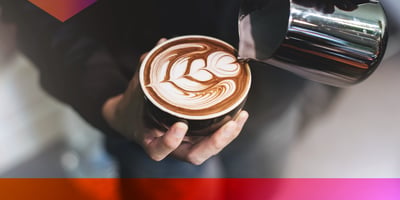 Barista pouring a cup of coffee with a stacked heart shaped latte art