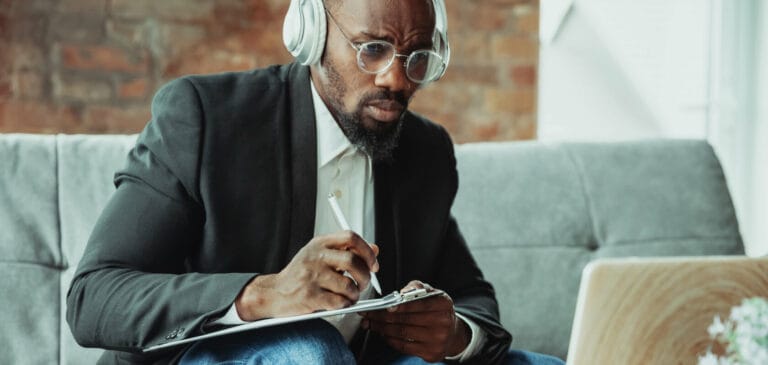 African-american man using laptop, tablet and headphones.