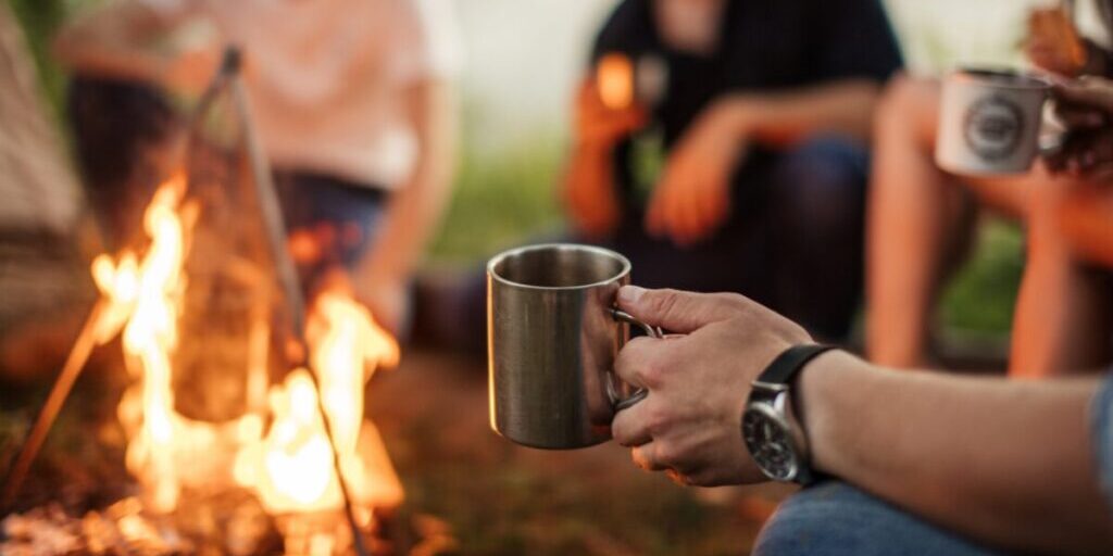 Image of group gathered around a bonfire having an effective team meeting.