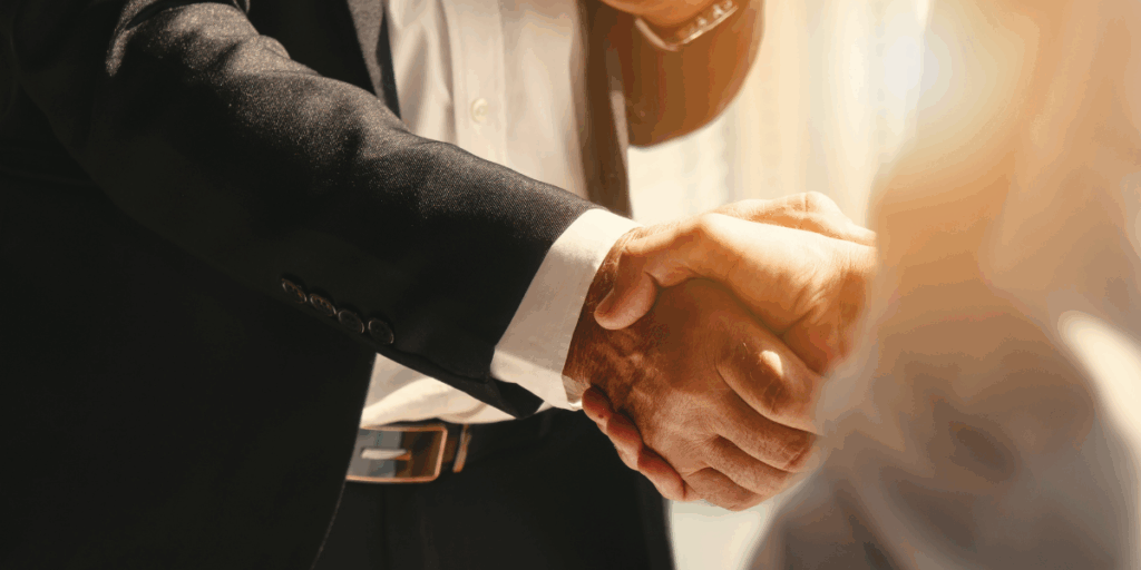 A person in a business suit shaking hands with a colleague